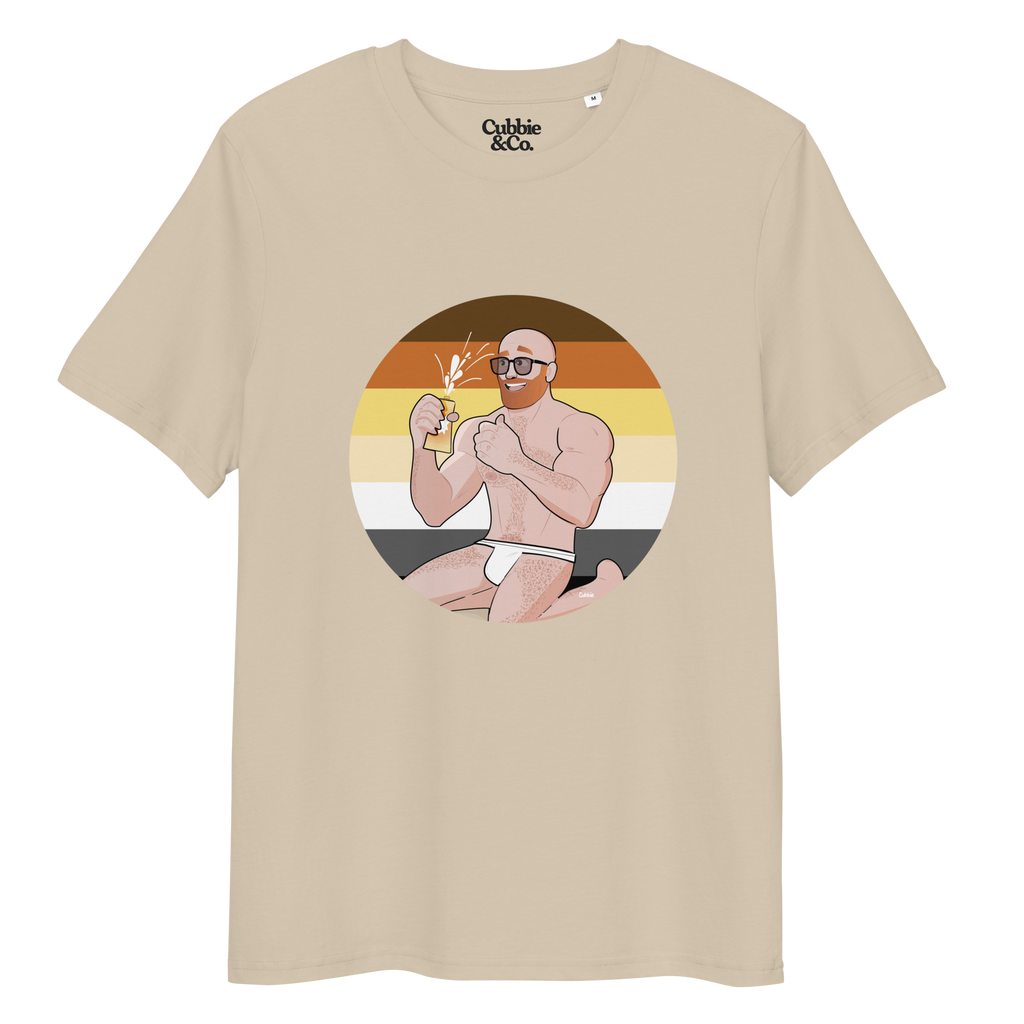 Desert dust t-shirt featuring Aaron the beach bear posing in front of a Bear Pride Flag as suncream spurts over his tight budgie smugglers