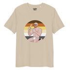 Desert dust t-shirt featuring Aaron the beach bear posing in front of a Bear Pride Flag as suncream spurts over his tight budgie smugglers