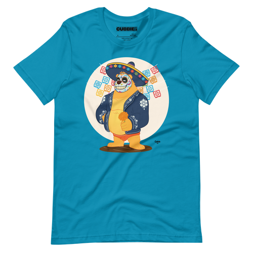 Bright aqua blue t-shirt featuring a cartoon LGBTQ+ bear character celebrating Day of the Dead, wearing a sombrero and traditional Mexican clothing