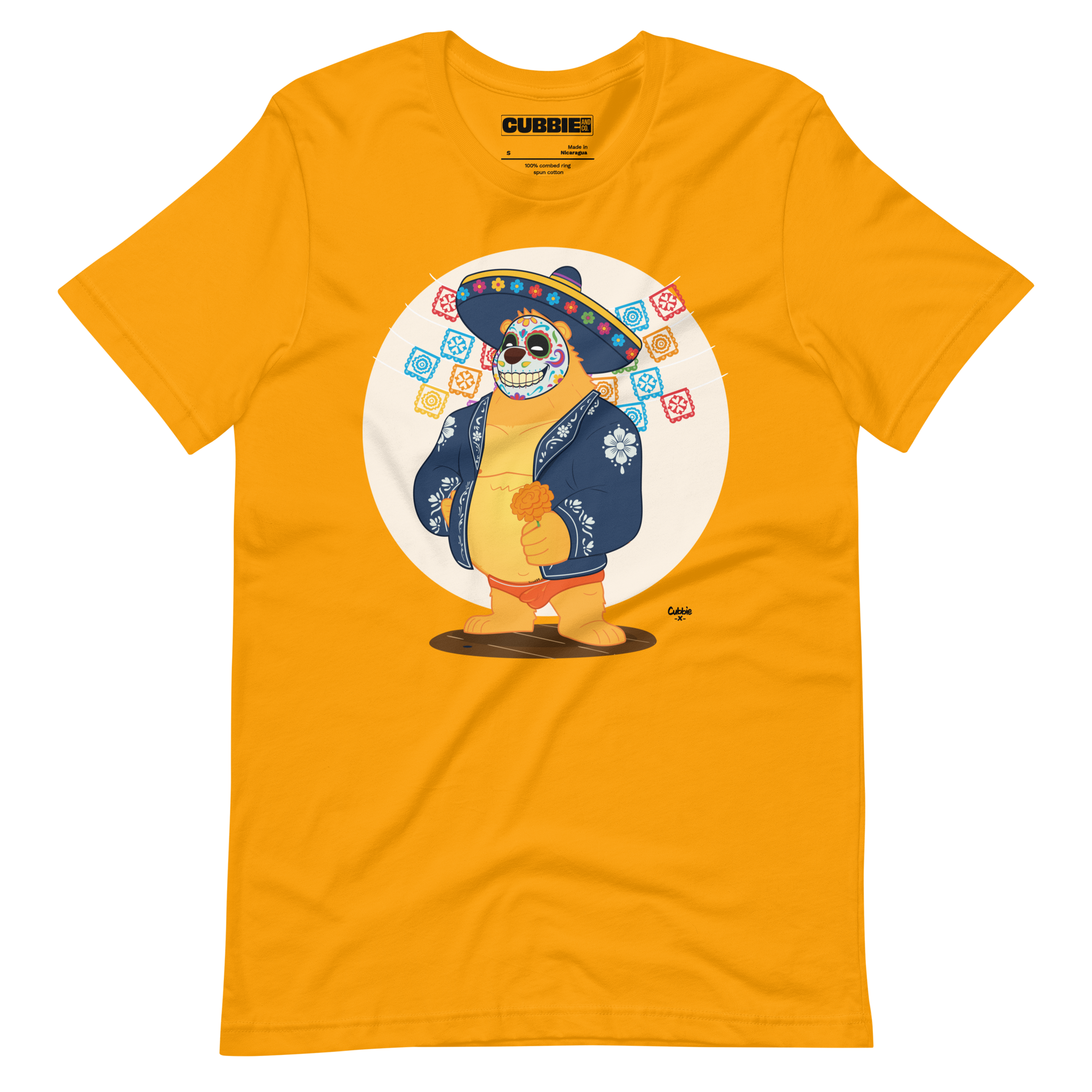Gold yellow t-shirt featuring a cartoon LGBTQ+ bear character celebrating Day of the Dead, wearing a sombrero and traditional Mexican clothing