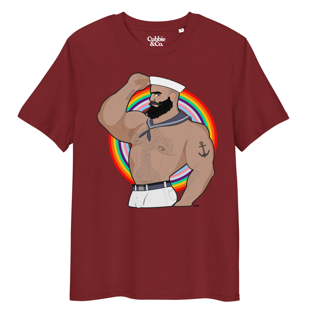 Burgundy t-shirt featuring Kitt the sailor shirtless with white sailor hat and pants, saluting and flexing, with anchor tattoo in front of a Pride rainbow